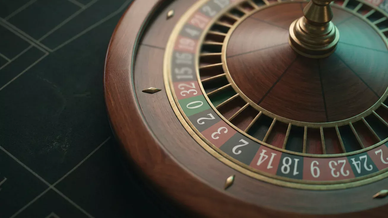 Mesa de ruleta europea con dealer presentando la rueda y la bola sobre el tapete